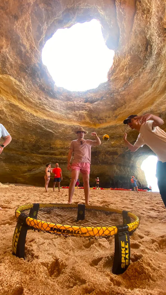 Two Spikeball players within a canyon cave in the middle of a game 